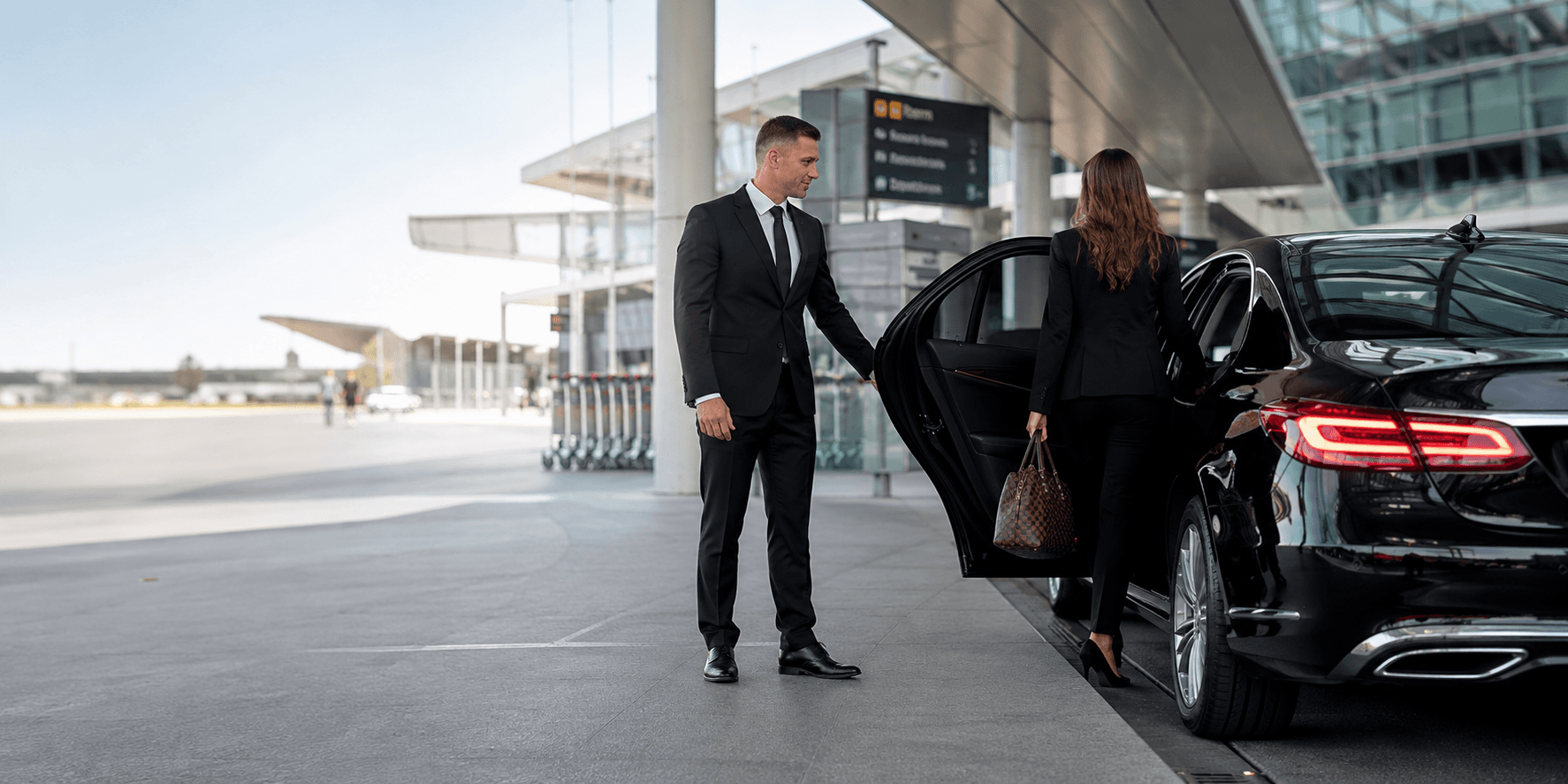 Executive chauffeur opening a luxury car for chauffeur services in Nelson